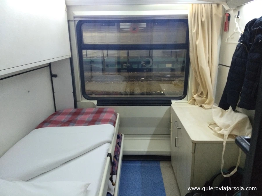Interior de la habitación del tren, con la cama y la mesa