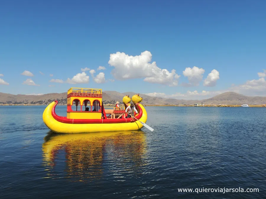Un barco de los Uros navegando por el lago Titicaca