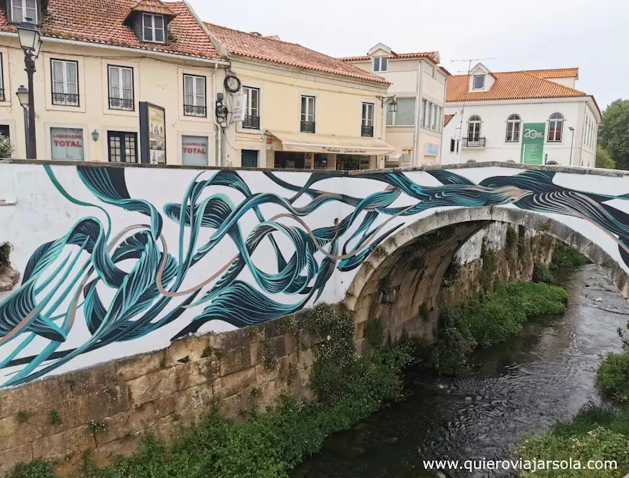 Un puente sobre el río con un mural