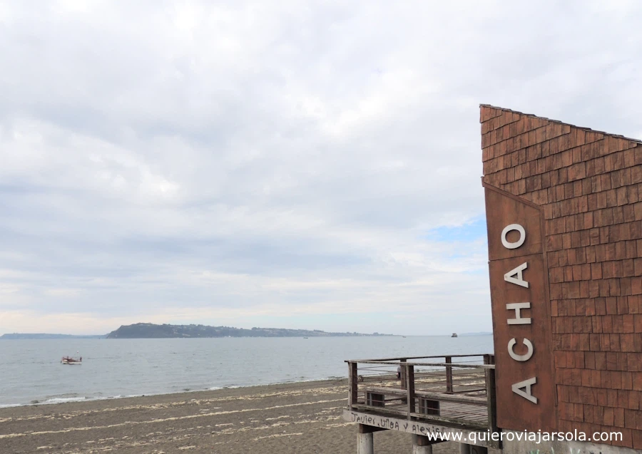 Vista del mar desde la costanera y un cartel de Achao