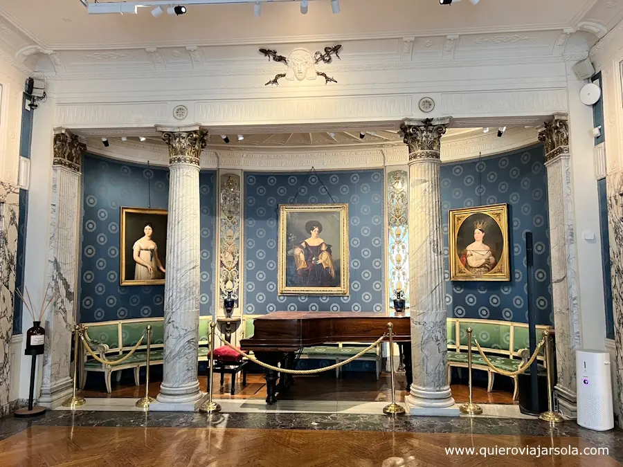Sala del museo con retratos y piano