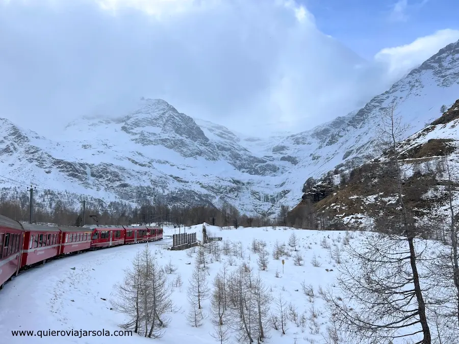 El tren circulando entre montañas nevadas