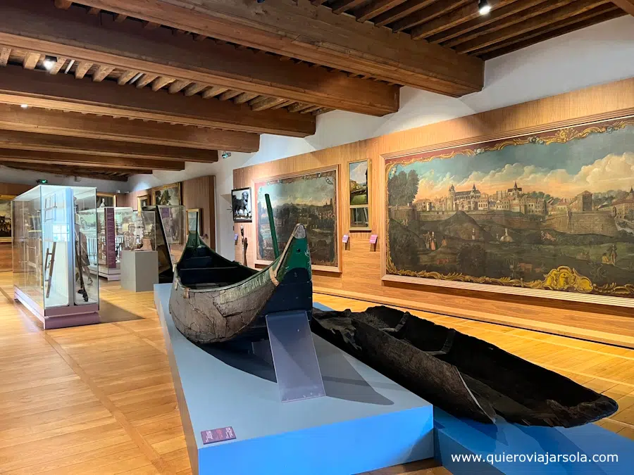 Barcos antiguos y pinturas en una sala del museo